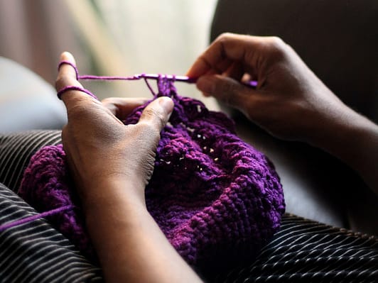 Leisure: A person relaxing and knitting.