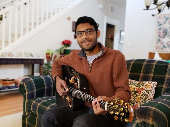 My son Nikhil's favorite pastime is playing guitar. Here he is sitting on a couch with his guitar. 